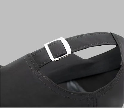 Black cap with a silver buckle on a light blue background